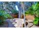 Beautifully landscaped backyard with a stone seating area, mature trees, and lush tropical foliage at 10130 Paddock Oaks Dr, Riverview, FL 33569