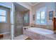 Elegant bathroom featuring a soaking tub with tile surround and a glass-enclosed shower at 10130 Paddock Oaks Dr, Riverview, FL 33569