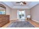 Bright bedroom with tray ceiling, hardwood floors, a dresser and backyard views at 10130 Paddock Oaks Dr, Riverview, FL 33569