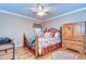 Cozy bedroom with a decorative metal bed frame, hardwood floors, and natural light at 10130 Paddock Oaks Dr, Riverview, FL 33569