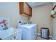 Functional laundry room with new washer/dryer set, utility sink, and storage cabinets at 10130 Paddock Oaks Dr, Riverview, FL 33569