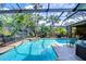 Inviting screened pool area surrounded by lush tropical landscaping and a lounge chair at 10130 Paddock Oaks Dr, Riverview, FL 33569