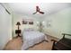 Comfortable bedroom with neutral color palette, fan, beachy decor, and closet at 1100 S Betty Ln, Clearwater, FL 33756