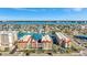 Aerial view of multi-Gathering housing with water view, docks, landscaping, and city in distance at 113 Island Way # 241, Clearwater Beach, FL 33767
