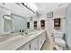 This bathroom features a long vanity, toilet and shower curtain with a framed mirror at 113 Island Way # 241, Clearwater Beach, FL 33767