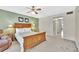 This bedroom features neutral carpet, a ceiling fan, and a green accent wall at 113 Island Way # 241, Clearwater Beach, FL 33767