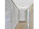 Hallway featuring a series of white louvered doors for closet space and tiled floor leading to the front door at 113 Island Way # 241, Clearwater Beach, FL 33767