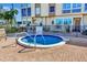Community hot tub surrounded by brick pavers and tropical landscaping near condo building at 113 Island Way # 241, Clearwater Beach, FL 33767