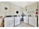 Laundry room with multiple washers and dryers, painted walls, and tiled flooring at 113 Island Way # 241, Clearwater Beach, FL 33767