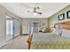 Bright main bedroom features a ceiling fan, a large bed, an exterior door and a dresser with ample space at 113 Island Way # 241, Clearwater Beach, FL 33767