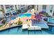 Aerial view of the community pool and dock area with lounge chairs and lush landscaping by the water at 113 Island Way # 241, Clearwater Beach, FL 33767