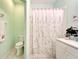 Bright bathroom with green walls, shower and tub combination, and vanity and commode at 11539 Captiva Kay Dr, Riverview, FL 33569
