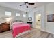 Bright bedroom features hardwood floors, a ceiling fan, and ensuite bathroom at 11539 Captiva Kay Dr, Riverview, FL 33569