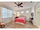Bright bedroom features hardwood floors, a ceiling fan, and white walls with sheer curtains at 11539 Captiva Kay Dr, Riverview, FL 33569