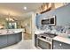Modern kitchen featuring a stainless steel oven, microwave, and stylish blue-and-white backsplash at 11539 Captiva Kay Dr, Riverview, FL 33569