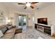 Bright living room featuring a leather sectional, ceiling fan, and sliding glass door to the patio at 11539 Captiva Kay Dr, Riverview, FL 33569