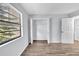 Bright bedroom featuring vinyl flooring, a window with blinds and a spacious closet at 12135 Environmental Dr # 2, New Port Richey, FL 34654