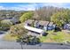 Aerial view of condo building with carports, green space, and a partial view of a lake on a sunny day at 12135 Environmental Dr # 2, New Port Richey, FL 34654