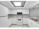 Well-lit kitchen featuring white appliances and tile flooring at 12135 Environmental Dr # 2, New Port Richey, FL 34654