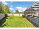 Spacious backyard features a well-maintained lawn, partial fencing, and a screened-in pool area for relaxation at 13411 Beechberry Dr, Riverview, FL 33579