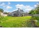 Beautiful backyard featuring a large lawn, mature plantings, and a screened-in pool area at 13411 Beechberry Dr, Riverview, FL 33579