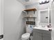 Bathroom featuring grey vanity, toilet with funny sign, and an open shelf at 13411 Beechberry Dr, Riverview, FL 33579