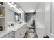 Modern primary bathroom with double vanity, marble countertops and a frameless glass shower enclosure at 13411 Beechberry Dr, Riverview, FL 33579
