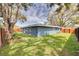 Backyard view featuring grass, trees, and the house at 1466 Laconia W Dr, Clearwater, FL 33764