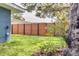 Backyard featuring grass, a tall wooden fence, and mature tree at 1466 Laconia W Dr, Clearwater, FL 33764