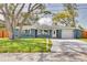 Charming one-story home with blue exterior paint, a well-manicured lawn, and a concrete driveway to the garage at 1466 Laconia W Dr, Clearwater, FL 33764