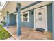 Inviting front porch with stone flooring, modern lighting fixtures, and a decorative front door with an oval window at 1466 Laconia W Dr, Clearwater, FL 33764