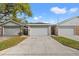 Street view of the home featuring attached one-car garage, stone facade accents and concrete driveway at 1763 Castle Rock Rd, Tampa, FL 33612