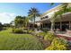 Restaurant with lakeside view featuring lush landscaping, outdoor seating, and beautiful architecture at 2202 Clubhouse Dr # 177, Sun City Center, FL 33573