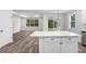 Kitchen island with white cabinets and countertops, adjacent to the living area at 2472 Orange Harvest Pl, Seffner, FL 33584