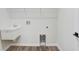 Bright laundry area features a sink, laminate flooring, and white walls at 2472 Orange Harvest Pl, Seffner, FL 33584