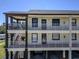 Multi-level condo building showing outdoor staircases, multiple balconies, and space for covered parking at 340 Causeway Blvd # 108, Dunedin, FL 34698