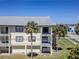 Multi-story condo building with balconies, surrounded by palm trees and well-maintained grounds at 340 Causeway Blvd # 108, Dunedin, FL 34698