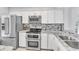 Bright kitchen featuring modern stainless steel appliances, light granite countertops, and white cabinets at 340 Causeway Blvd # 108, Dunedin, FL 34698
