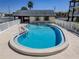 Inviting community pool with a white picket fence and a charming clubhouse, perfect for recreation at 340 Causeway Blvd # 108, Dunedin, FL 34698