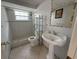 Clean bathroom with tiled walls, a pedestal sink, and a walk-in shower at 3601 Landale Dr, Holiday, FL 34691