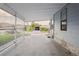 Covered carport area featuring concrete flooring, a view of the front yard and an adjacent home at 3921 Chris Dr, Wesley Chapel, FL 33543