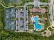 An aerial shot shows the community's amenities, which include a pool, tennis courts, parking, and a clubhouse, all set amongst lush greenery at 4522 Tramanto Ln, Wesley Chapel, FL 33543