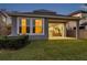 Exterior view of the home featuring a well-maintained lawn and sliding glass doors to the patio at 4522 Tramanto Ln, Wesley Chapel, FL 33543