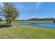 Backyard featuring a large pond and lush green lawn at 4522 Tramanto Ln, Wesley Chapel, FL 33543