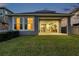 View of the backyard with a covered patio and large sliding glass doors leading into the living area at 4522 Tramanto Ln, Wesley Chapel, FL 33543