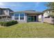 Backyard view of a covered patio, well-maintained lawn, and privacy fence at 4522 Tramanto Ln, Wesley Chapel, FL 33543