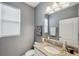 Cozy bathroom with granite countertop vanity, neutral tones, and a decorative mirror at 4522 Tramanto Ln, Wesley Chapel, FL 33543