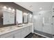 Modern bathroom featuring double sinks, white cabinetry, and a glass-enclosed shower with white tile surround at 4522 Tramanto Ln, Wesley Chapel, FL 33543