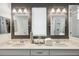 Elegant bathroom vanity with dual sinks, granite countertops, and stylish lighting fixtures at 4522 Tramanto Ln, Wesley Chapel, FL 33543