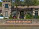 Elegant clubhouse entrance with a stone facade, barrel tile roof and well manicured landscaping at 4522 Tramanto Ln, Wesley Chapel, FL 33543